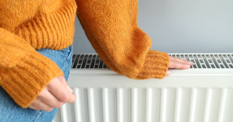 γυναικα ακουμπαει με το χερι της ενα καλοριφερ
